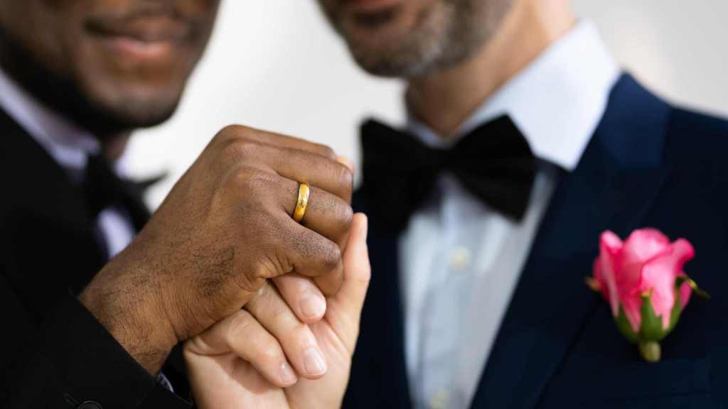 Two LGBT gay men, one black and one white, holding hands; meant to symbolize how to fix your marriage with couples therapy intensives or couples therapy retreats.