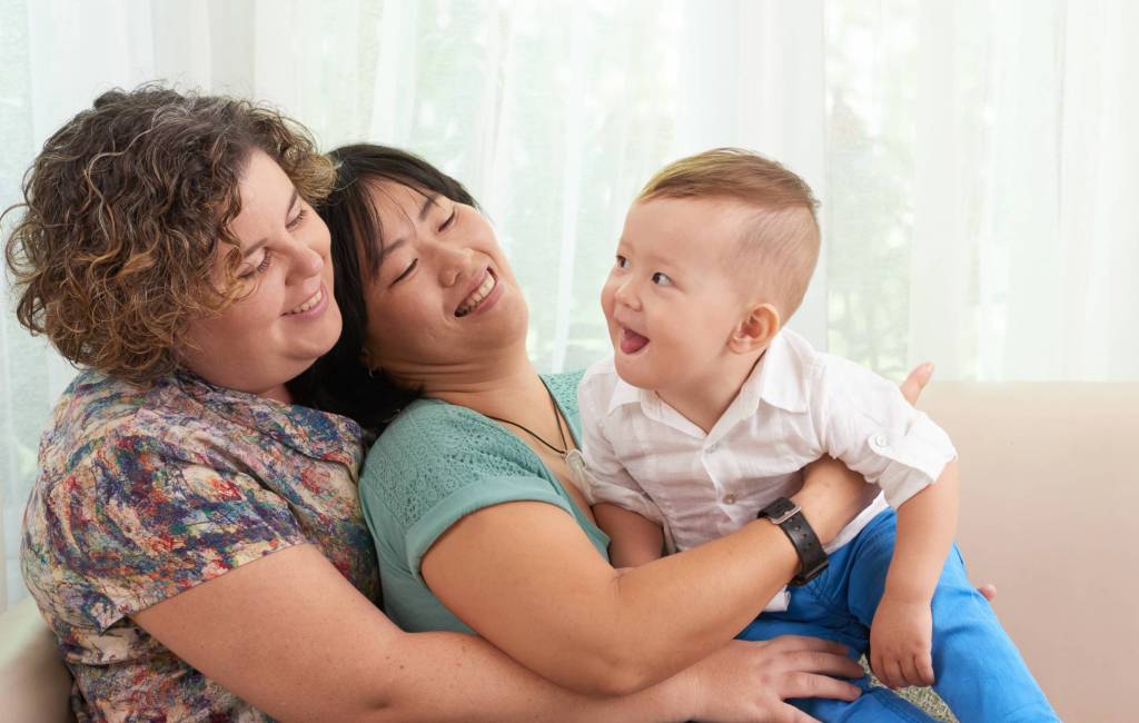 Two LGBT lesbian women holding a toddler; symbolizing how to fix your relationship with a couples therapy intensive or couples therapy retreat.